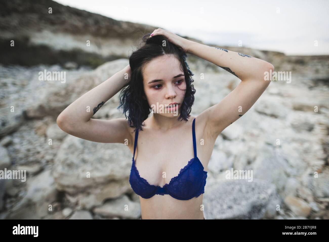 Jeune femme avec soutien-gorge bleu sur la plage Banque D'Images