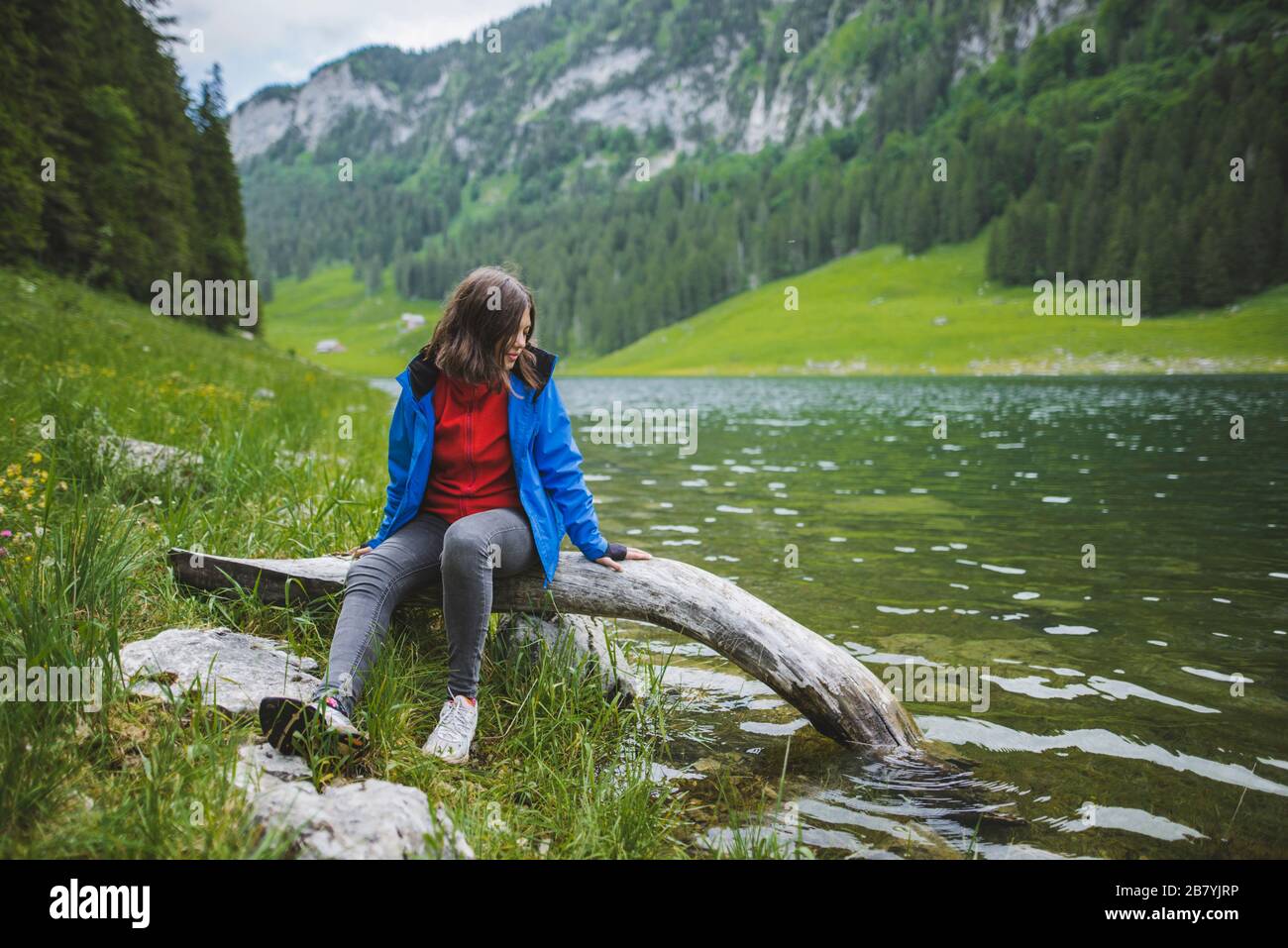 Jeune femme assise en bois près du lac Banque D'Images