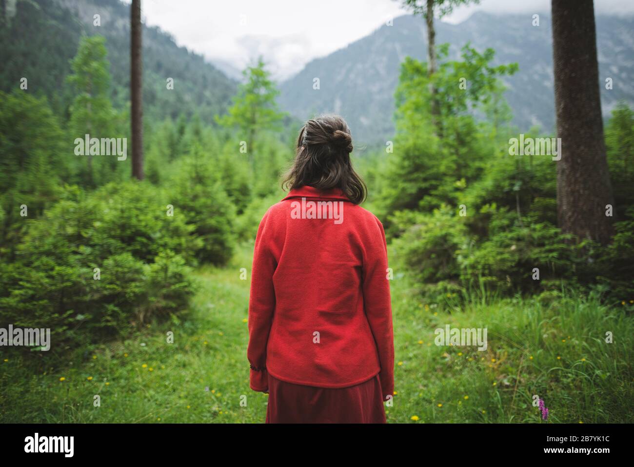Jeune femme avec veste rouge en forêt Banque D'Images