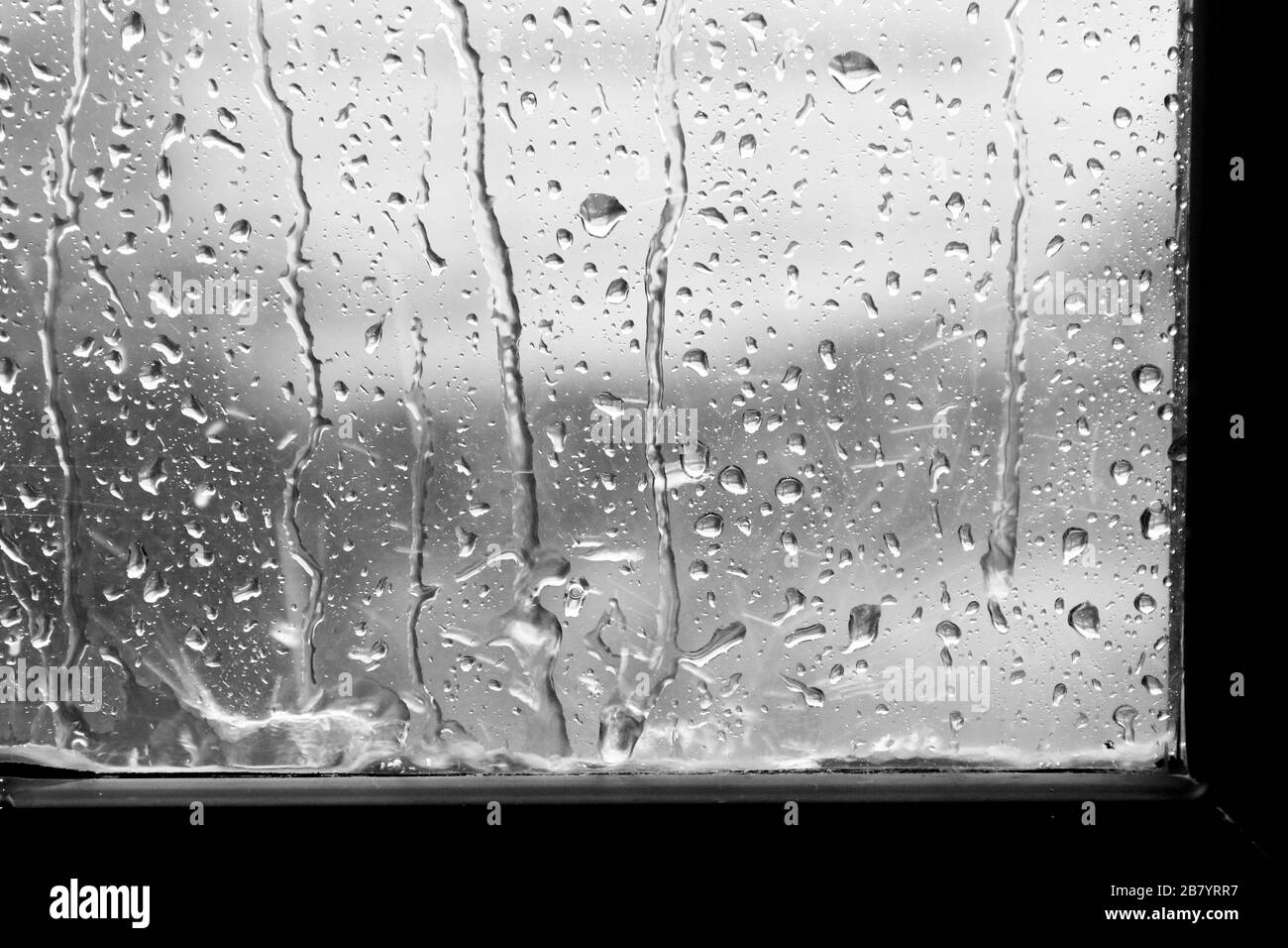 fond sombre pluie sur fenêtre verre gris Banque D'Images