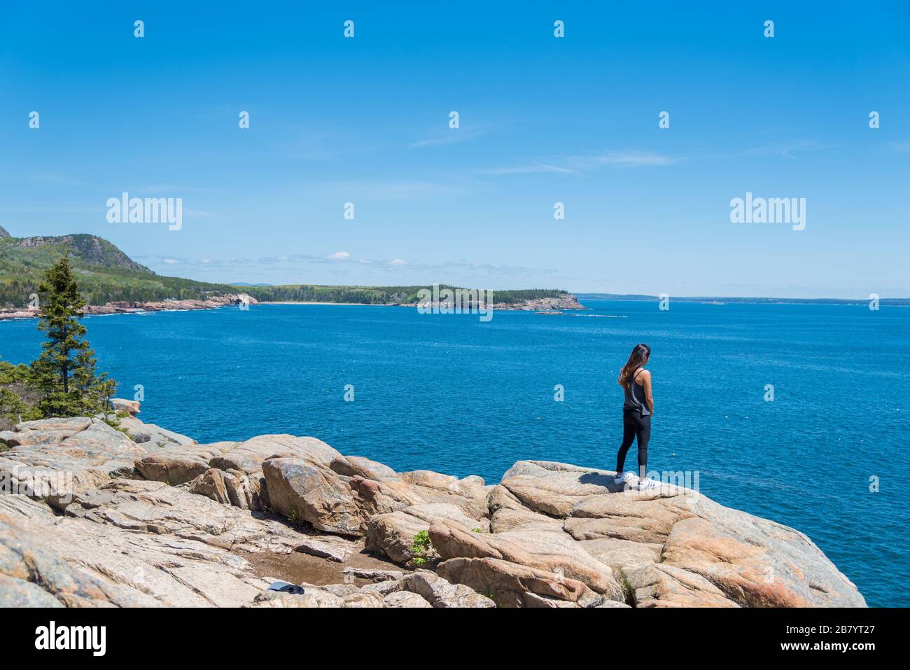 Une femme qui jouit de la vue magnifique sur l'océan Atlantique forme la côte dans le parc national Acadia Maine USA Banque D'Images