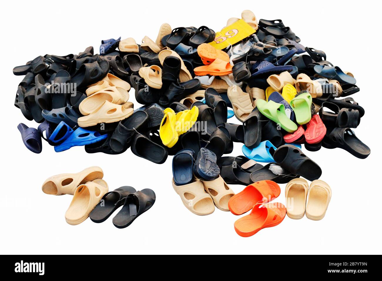 Piles de chaussures vendues dans diverses combinaisons de couleurs marché rural de terre, sandales, chaussures décontractées, vieux. Isolé sur fond blanc Banque D'Images