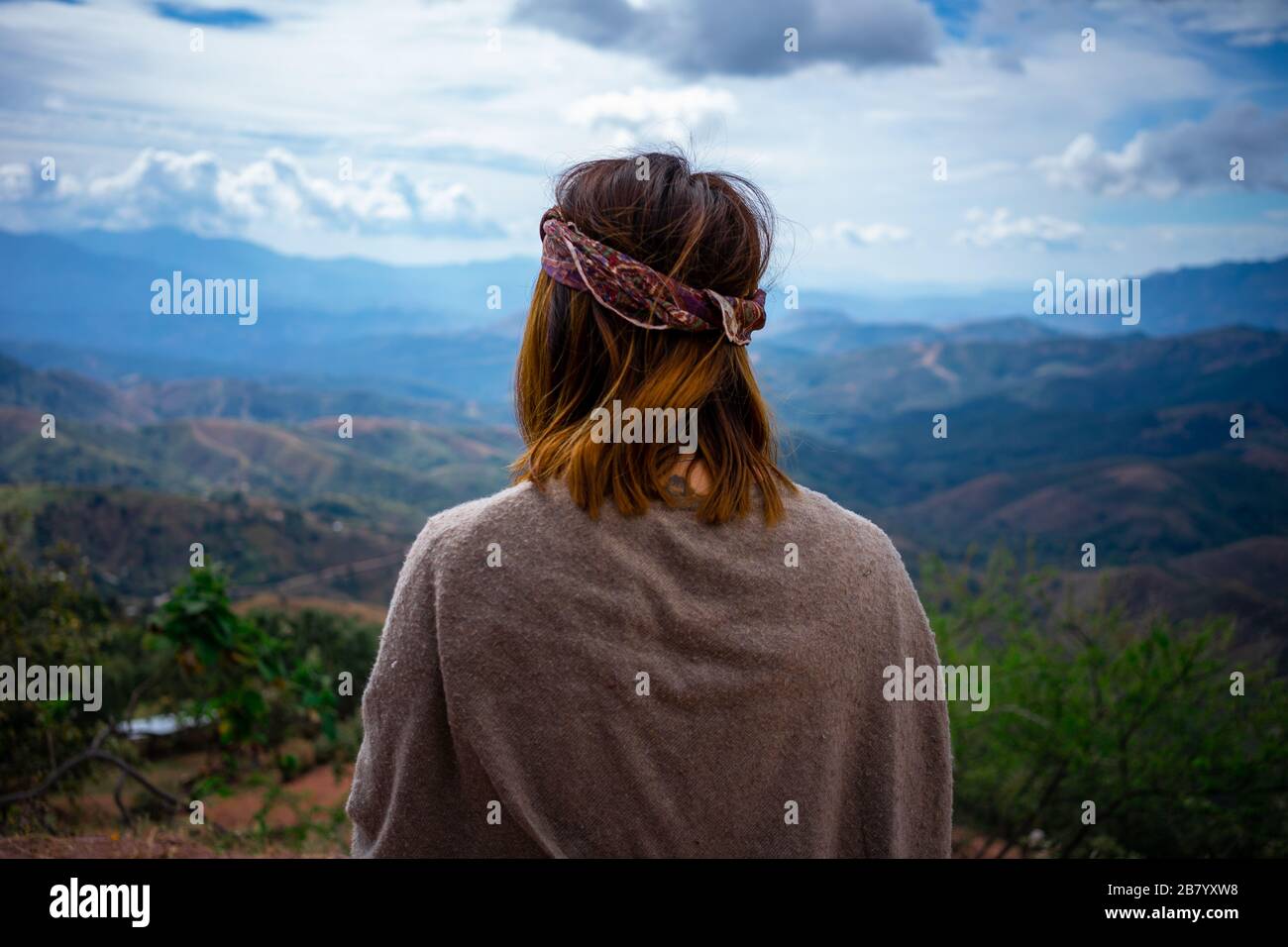 fille hippie regardant l'immensité des montagnes du sommet de l'un d'eux Banque D'Images