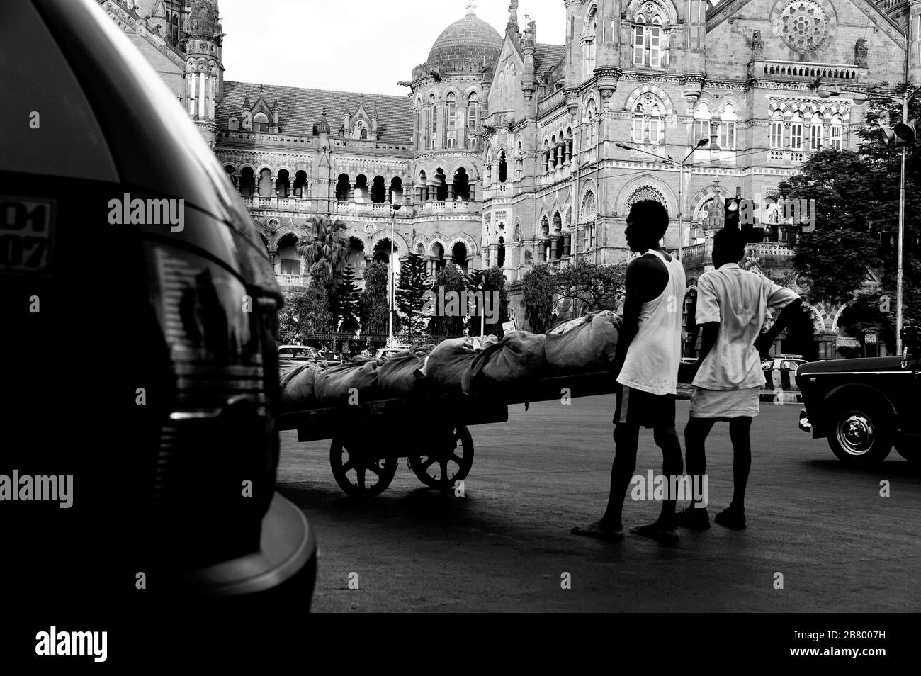 Homme poussant à la main, Victoria Terminus VT, Chhatrapati Shivaji Maharaj Terminus CST, site du patrimoine mondial de l'UNESCO, Bori Bunder, Bombay, Inde Banque D'Images