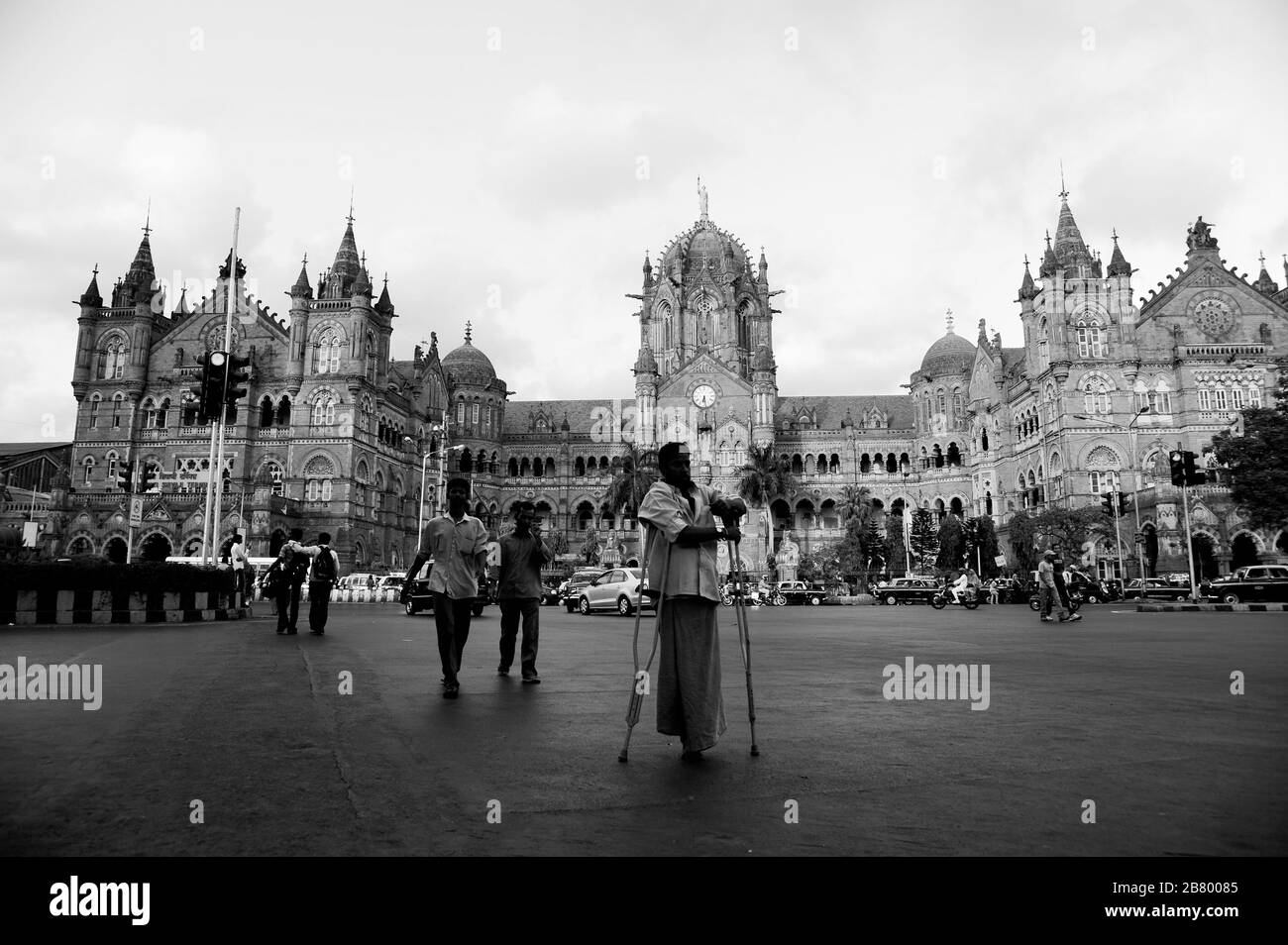 Homme avec la route des béquilles, Victoria Terminus VT, Chhatrapati Shivaji Maharaj Terminus CST, site du patrimoine mondial de l'UNESCO, Bori Bunder, Bombay, Inde Banque D'Images