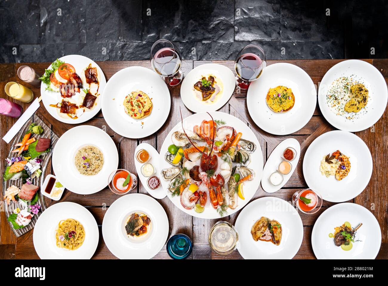 Vue sur le plan de table variété de plats internationaux de qualité dans le restaurant de crevettes de homard steak boeuf agneau pâtes spaghetti risotto riz sushi sashimi et wi Banque D'Images