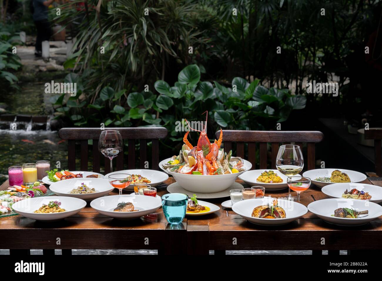 Vue latérale variété de spécialités internationales dans le jardin du restaurant de crevettes de homard steak boeuf agneau pâtes spaghetti risotto riz sushi sashimi a Banque D'Images
