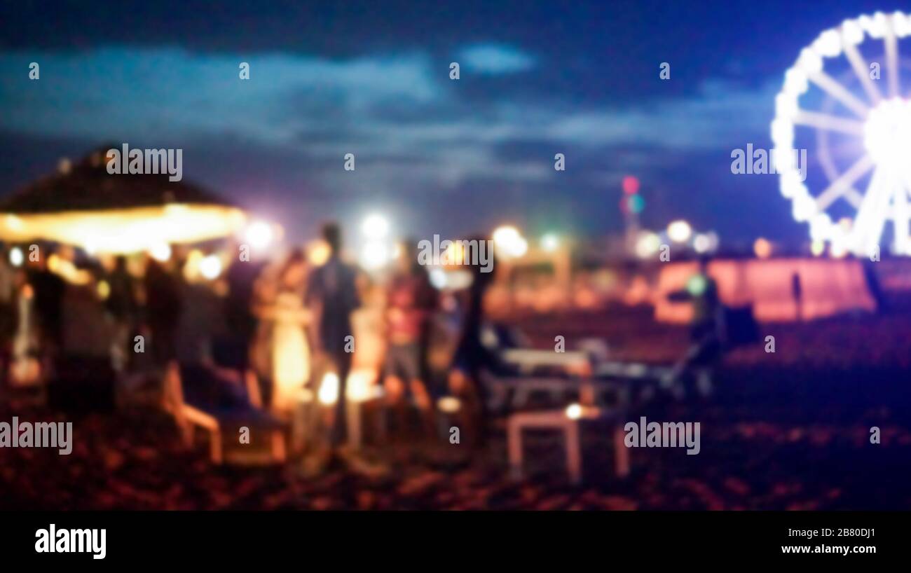 Des gens floutés qui ont fait la fête au coucher du soleil sur la plage en été - image Déféodée - concept de vie nocturne avec cocktails et divertissement musical Banque D'Images