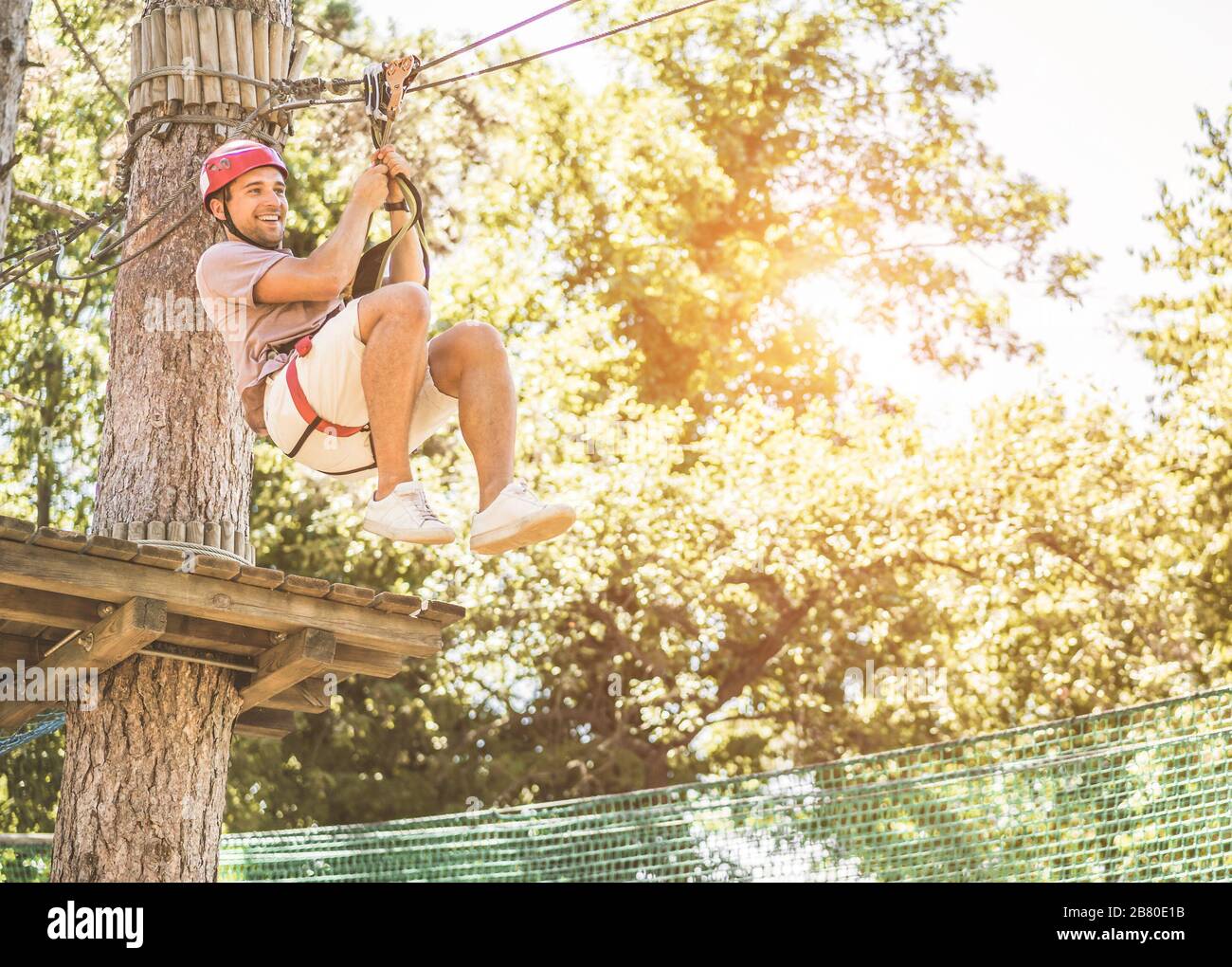 Touriste homme ayant du plaisir dans l'aventure parc naturel extérieur - jeune homme heureux faisant le sport extrême en week-end vacances - Voyage, Wanderlust et l'été va Banque D'Images Touriste homme ayant du plaisir dans l'aventure parc naturel extérieur - jeune homme heureux faisant le sport extrême en week-end vacances - Voyage, Wanderlust et l'été va Banque D'Images