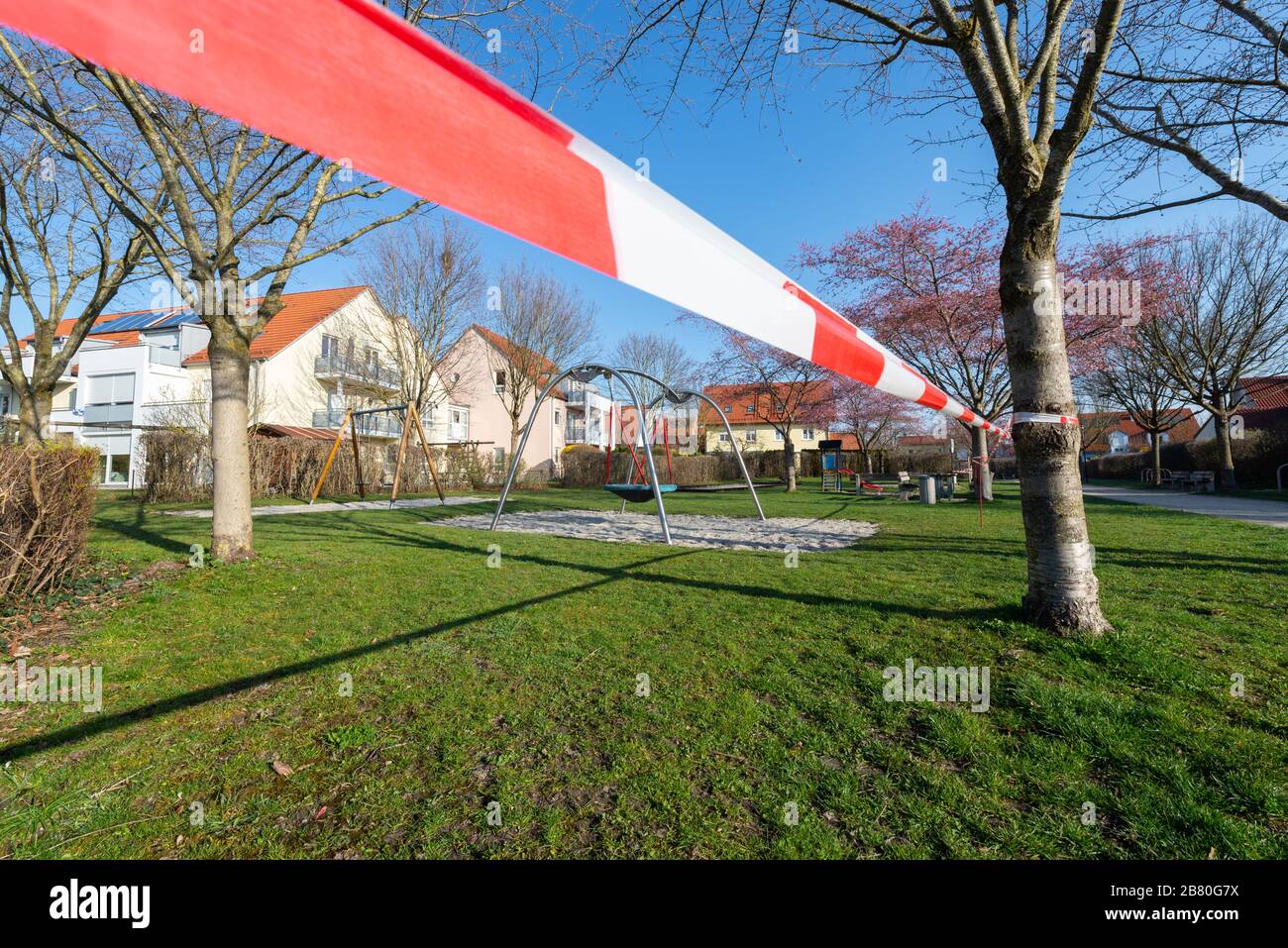 Rot-weisses Absperrband an einem gesperrten Kinderspielplatz während der Corona-KRise in Deutschland Banque D'Images