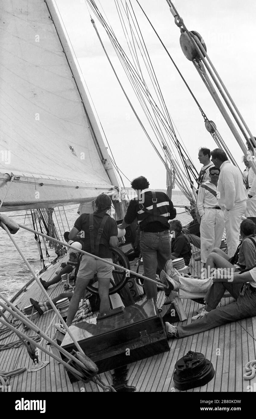 Équipage et clients payant à bord du yacht J Class 'Velsheda' après la première repose, voile dans le Solent, Hampshire, Angleterre, Royaume-Uni, été 1991. Archiver la photographie de film noir et blanc Banque D'Images