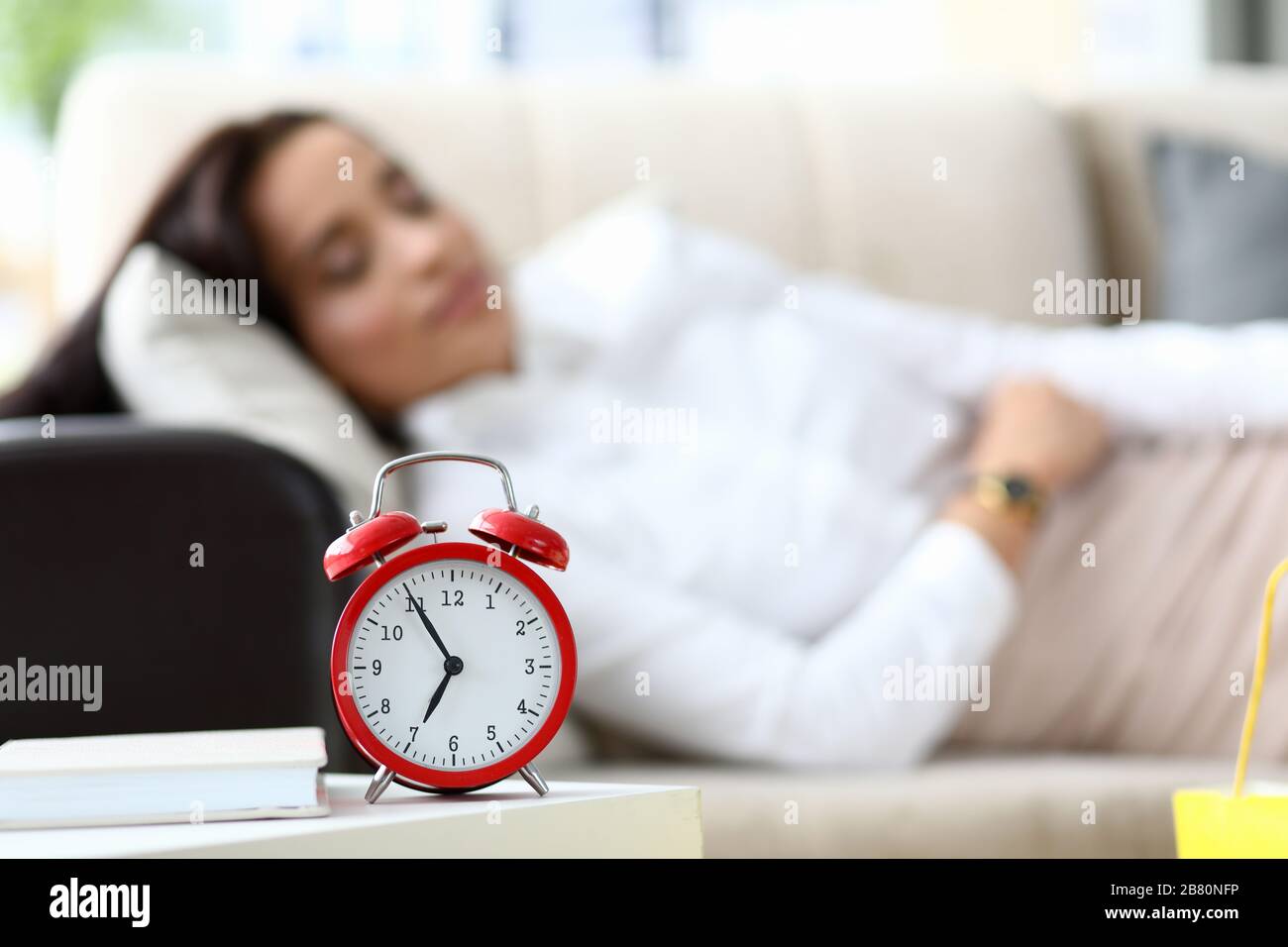 Fille est fatiguée et se trouve sur la table un réveil Banque D'Images Fille est fatiguée et se trouve sur la table un réveil Banque D'Images