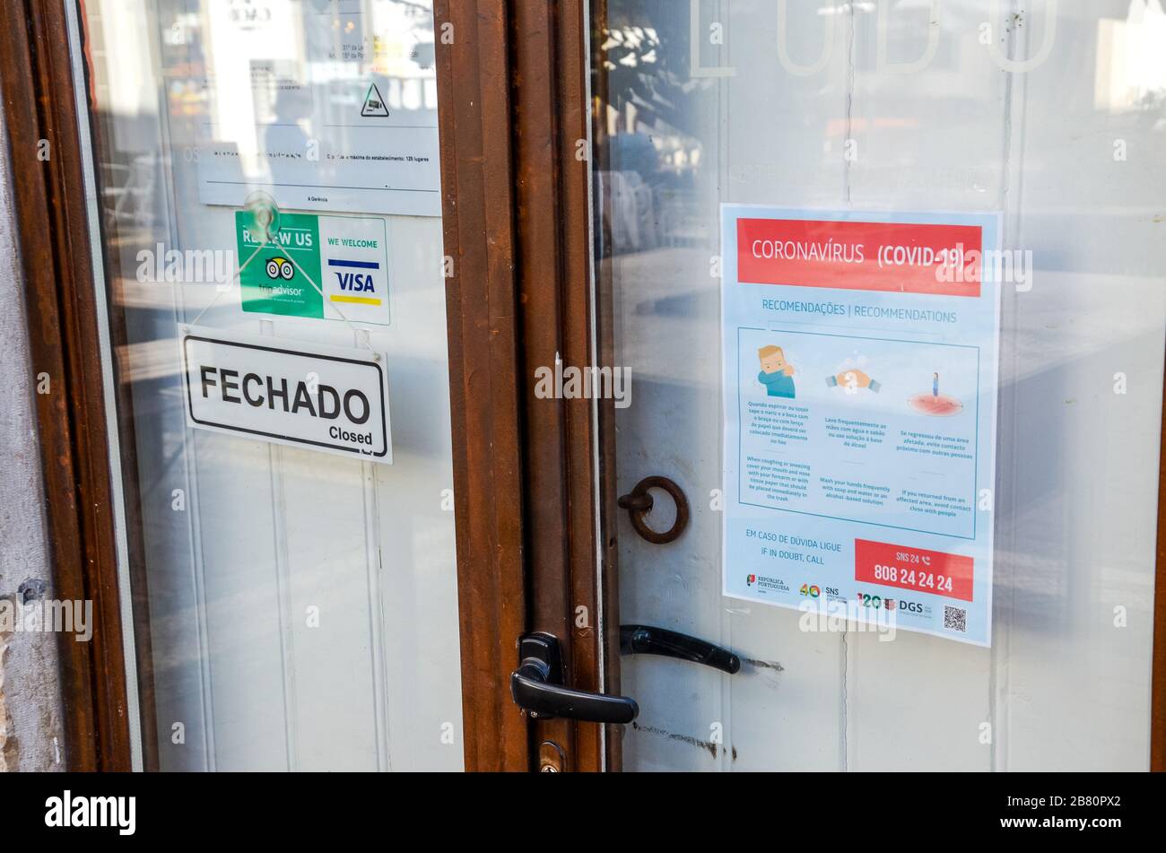 Faro, Portugal - 16 mars 2020 : porte avant fermée du restaurant avec notice d'instructions sur la sécurité du coronavirus en portugais et en anglais. Les restaurants sont fermés en raison de l'éclosion de COVID-19. Banque D'Images