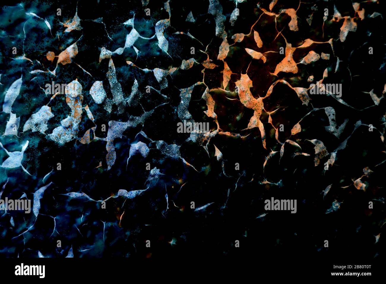 Texture de surface avec couleurs bleu, orange et noir avec une structure de surface fortement fissurée. Pour les arrière-plans abstraits. Allemagne Banque D'Images