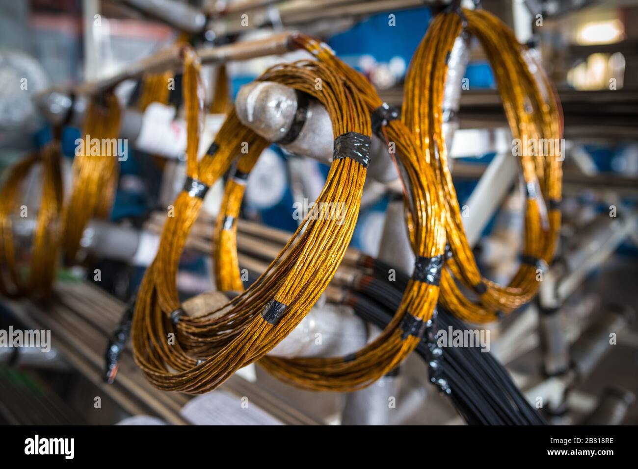 Les fils de cuivre torsadé se trouvent sur des racks métalliques pour la production de grandes pièces industrielles et pour la construction navale et les machines. Concept de pièces de rechange et pièces f Banque D'Images
