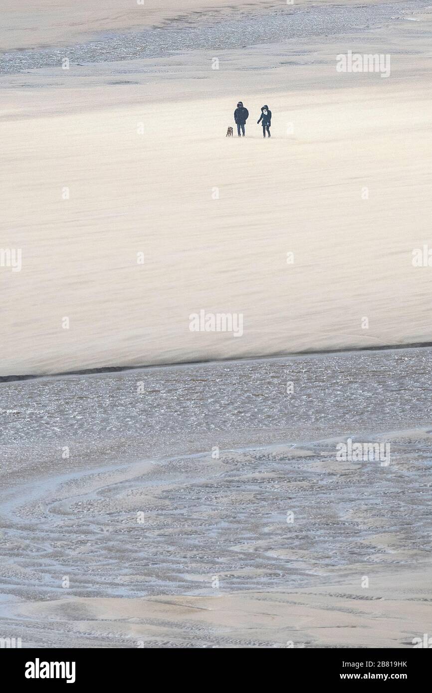 Marcheurs pour chiens sur la plage de Crantock à Newquay, à Cornwall. Banque D'Images
