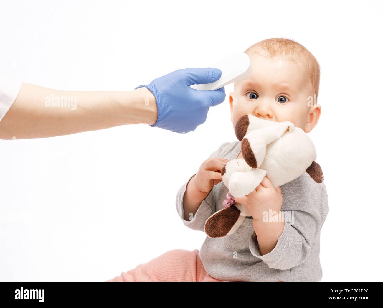 Le pédiatre ou l'infirmière vérifie la température corporelle du bébé  garçon à l'aide d'un thermomètre frontal infrarouge (pistolet thermomètre)  pour les symptômes de maladie Photo Stock - Alamy