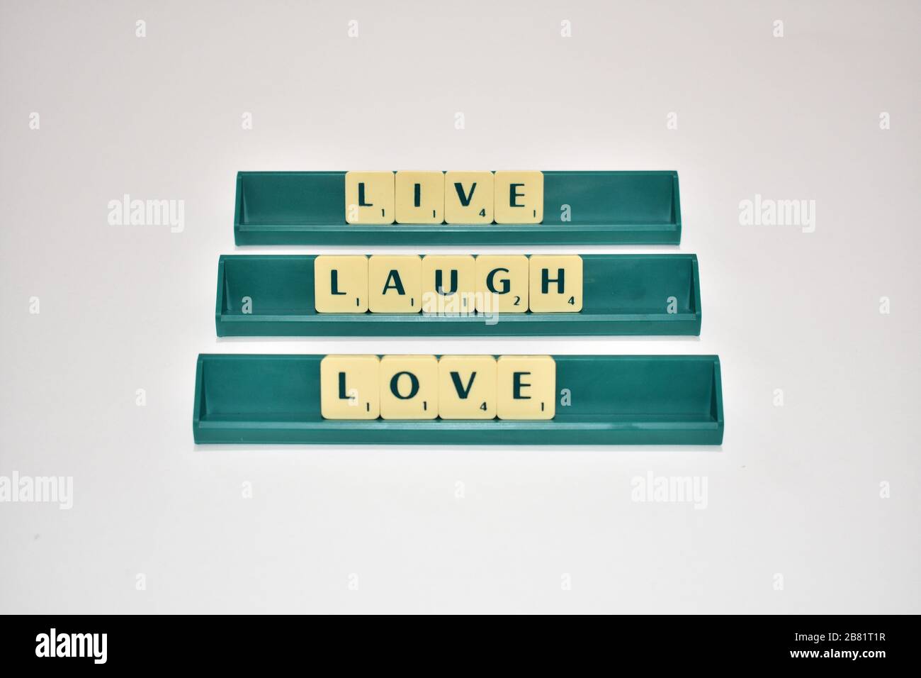 Les tuiles de Scrabble épeler Live rire Love Motivational citation blocs de Scrabble lettres gris arrière-plan vie citation induire Alphabet. Banque D'Images