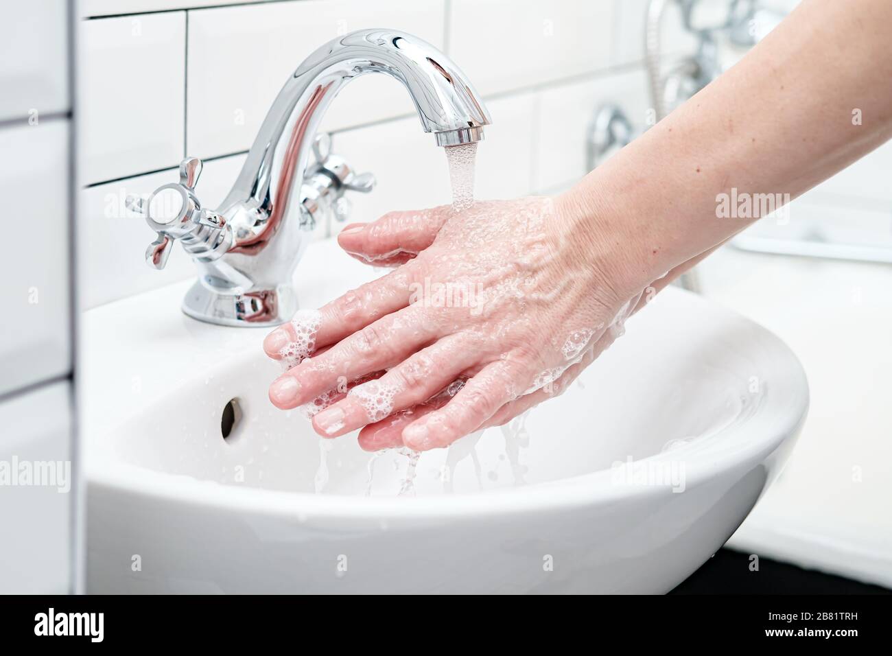 Laver les mains avec du savon sous l'eau courante pour protéger contre un virus dangereux. Concept de santé. Gros plan. Banque D'Images