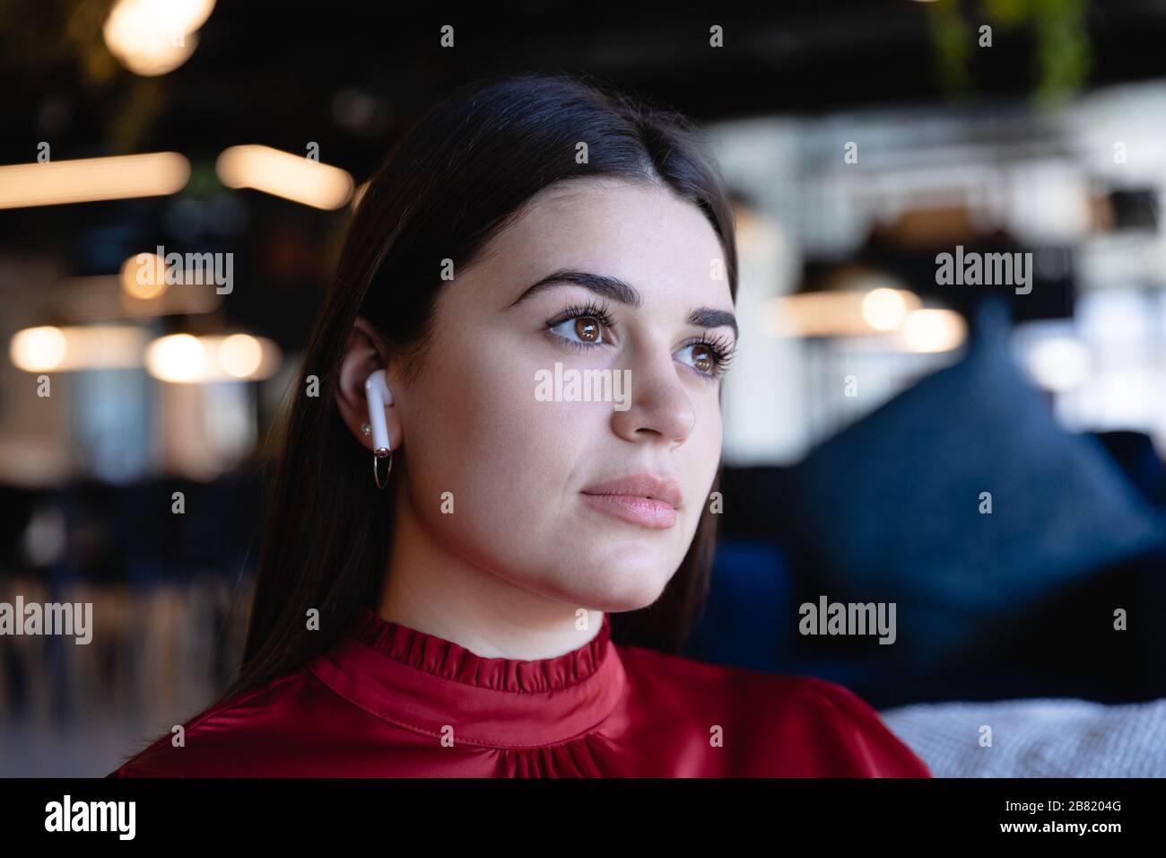 Femme caucasienne portant des écouteurs sans fil Banque D'Images