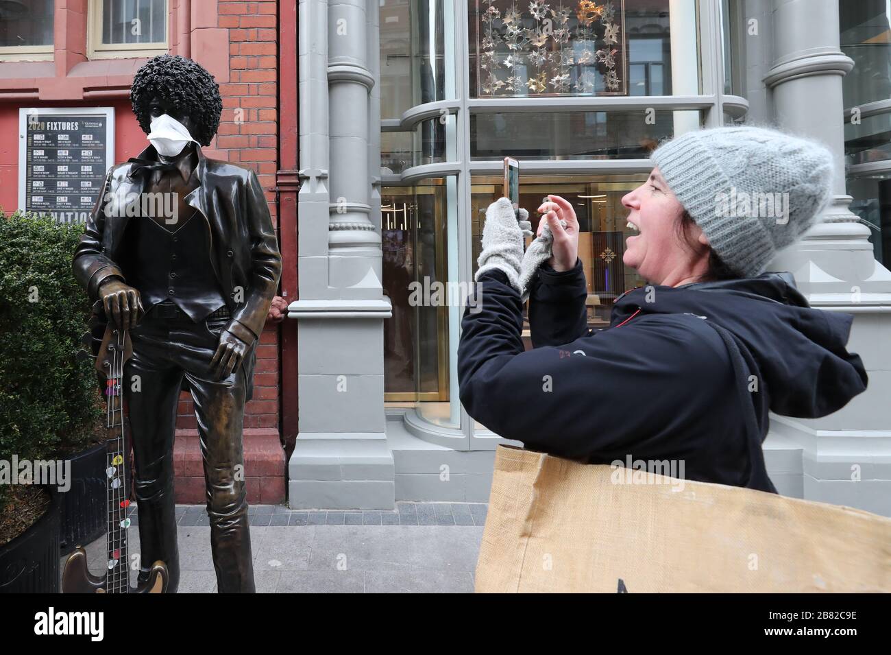 Les gens prenant des photos de la statue de Phil Lynott vêtu d'un masque de visage sur Grafton Street à Dublin, comme NHS Angleterre a annoncé que le nombre de morts de coronavirus avait atteint 137 au Royaume-Uni. Banque D'Images