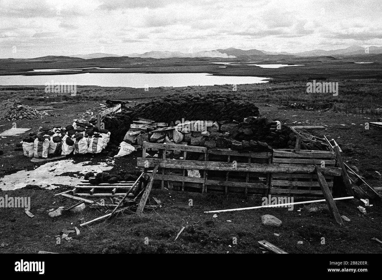 Tourbe fraîchement coupée empilée sur une étendue de terre sur l'île de Lewis dans les Hébrides extérieures, en Écosse. La coupe de la tourbe était une méthode traditionnelle de collecte de carburant pour l'hiver dans les régions peu peuplées de la côte ouest de l'Écosse et des îles. La tourbe a été séchée et utilisée dans les feux et les fours. Banque D'Images