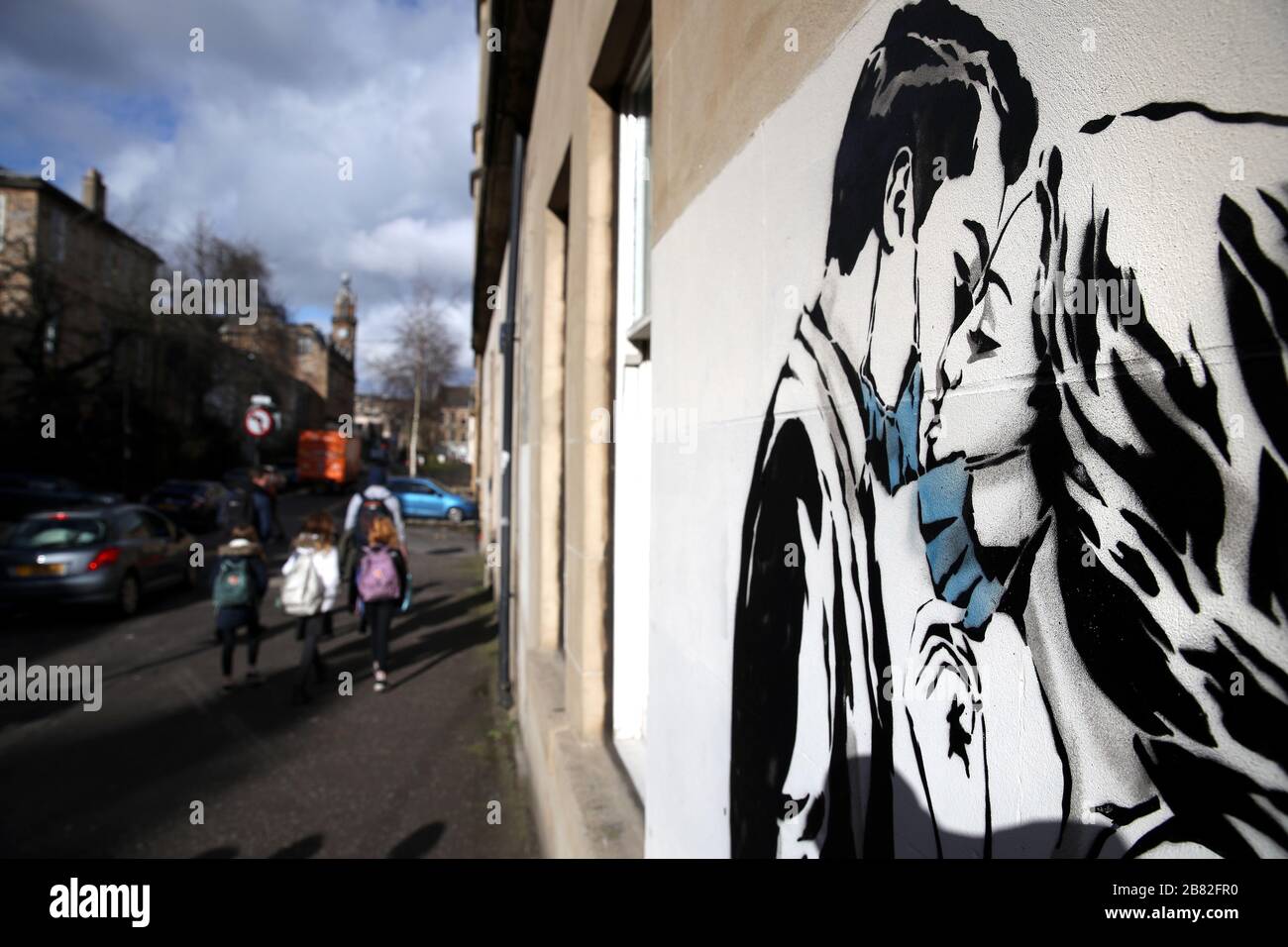 Un morceau d'art de l'artiste, connu sous le nom de Rebel Bear, est apparu sur un mur de Bank Street à Glasgow. Le nouvel ajout à l'art de la rue de Glasgow capture la crise mondiale du Coronavirus. La pièce comporte une femme et un homme tirant vers l'arrière pour se donner un baiser. Banque D'Images