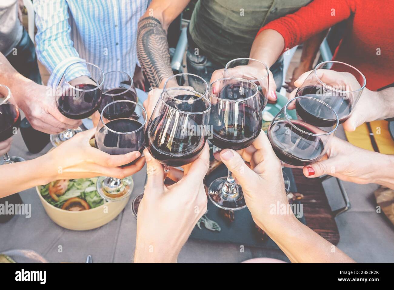 Bonne dégustation familiale avec des verres à vin rouge au dîner en plein air - les gens s'amusent à se faire plaisir et à boire tout en dînant ensemble Banque D'Images