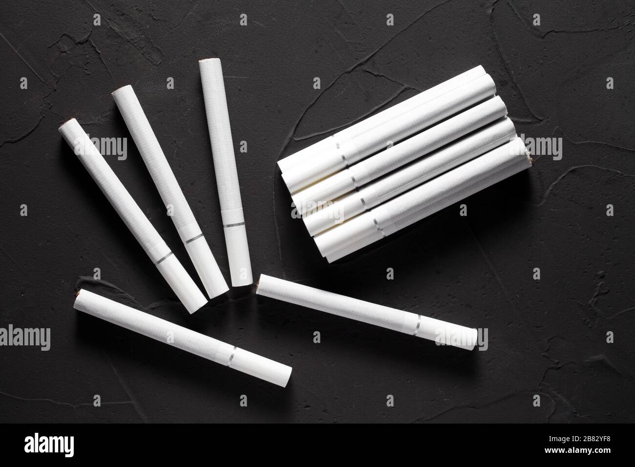 Cigarettes avec un filtre blanc sur un fond en béton sombre Photo Stock -  Alamy
