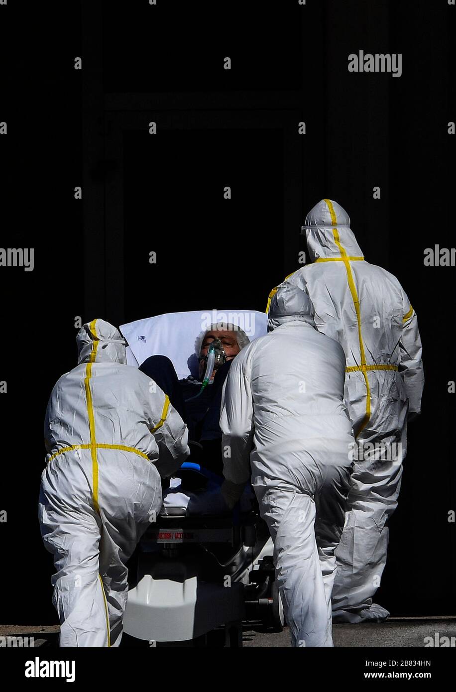 Les paramédics portent un patient Coronavirus COVID-19 avec une civière, pour le porter au service hospitalier où il sera traité Banque D'Images