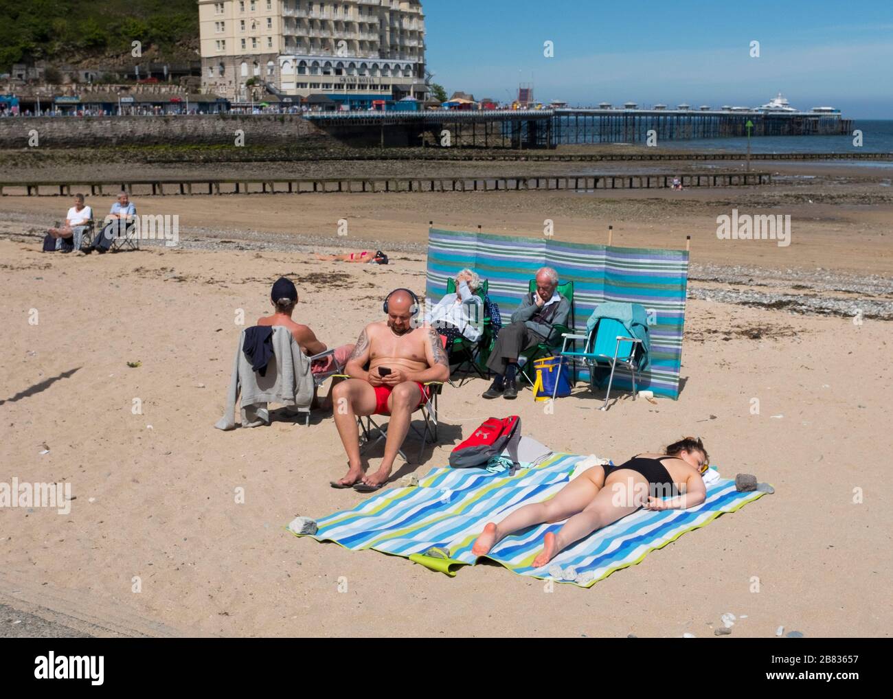 Les gens se bronzer sur la plage à Llandudno, pays de Galles, Royaume-Uni. Banque D'Images