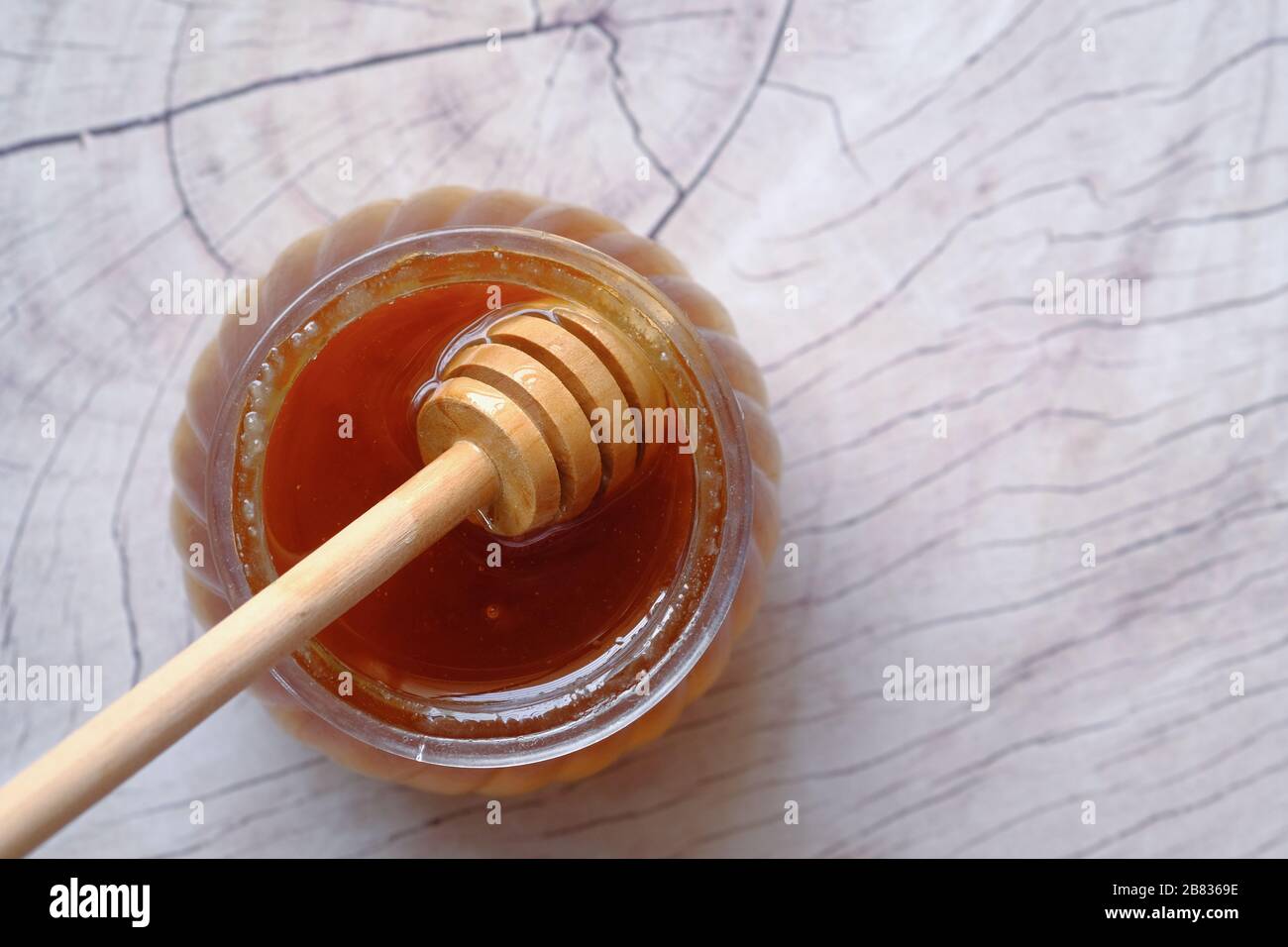 pot en verre plein de miel sur la table, vue sur le dessus . Banque D'Images