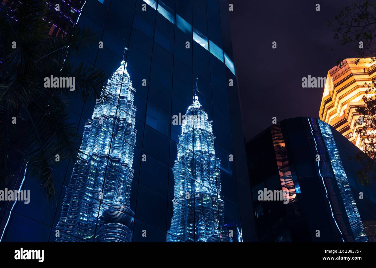 Kuala Lumpur, Malaisie - 28 novembre 2019 : vue nocturne du centre-ville avec reflet des tours jumelles Petronas dans un mur de verre bleu Banque D'Images