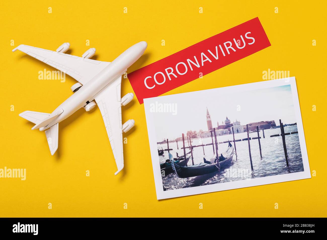 Jouet avion, un tag avec l'inscription et une photo de vacances sur un fond jaune. Concept de coronavirus en Italie Banque D'Images