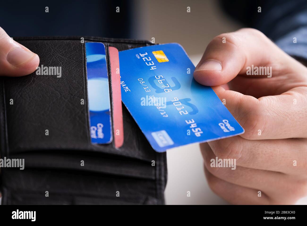 Image rognée d'un homme d'affaires montrant une carte de crédit dans le portefeuille au bureau Banque D'Images