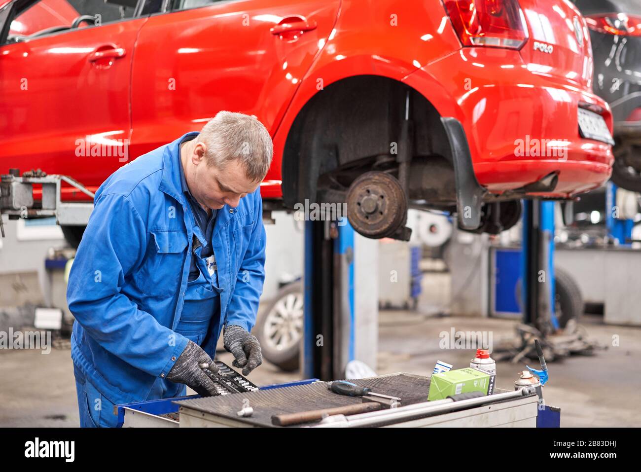 Russie, Nizhny Novgorod - 13 mars 2020: Meilleur service auto. Le mécanicien automatique change les freins de la voiture. Freins à tambour rouillés, arrière sur la voiture rouge Banque D'Images