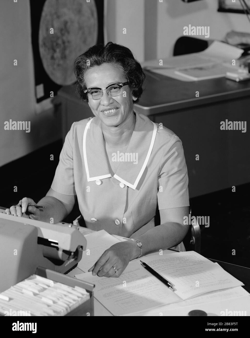 Portrait de Katherine Johnson, pionnière en informatique humaine de la NASA et en mathématiques afro-américaines (1918-2020), souriant, à un bureau avec notes, 1966. Image de courtoisie NASA. () Banque D'Images