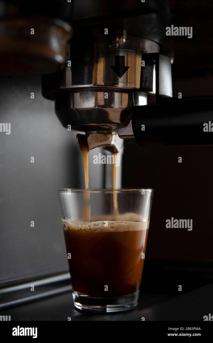 Gros plan d'une machine à café qui verse du café dans des tasses Banque D'Images