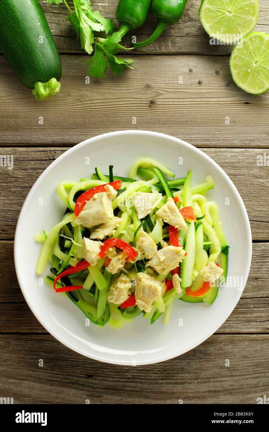 Plat de nouilles aux courgettes en bonne santé avec du poulet sur fond de bois, overhead view Banque D'Images