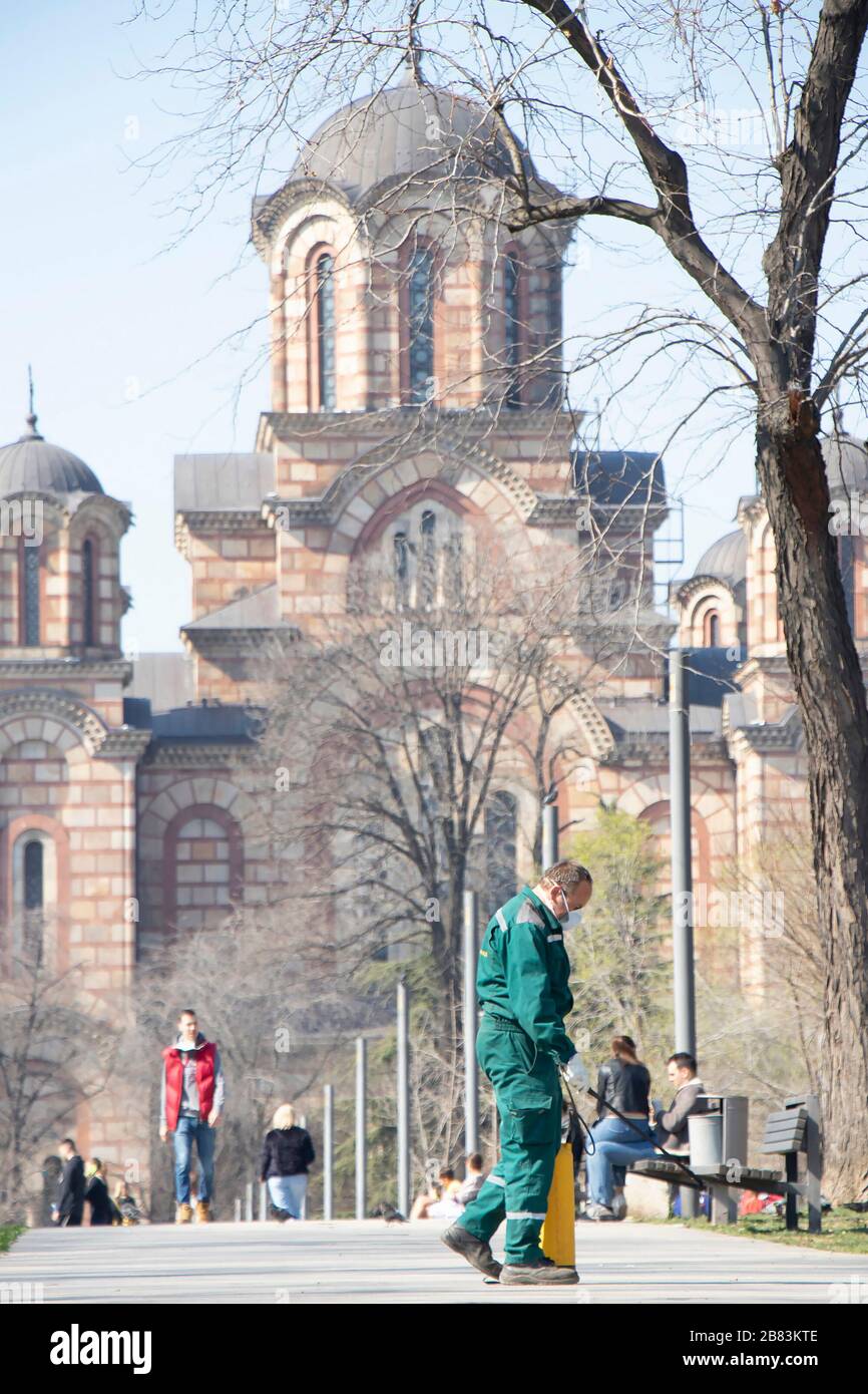 Belgrade, Serbie - 19 mars 2020: Travailleur de la verdure de la ville faisant une désinfection en plein air pulvérisation pour la prévention de la propagation du virus Corona à Tasmajdan Banque D'Images