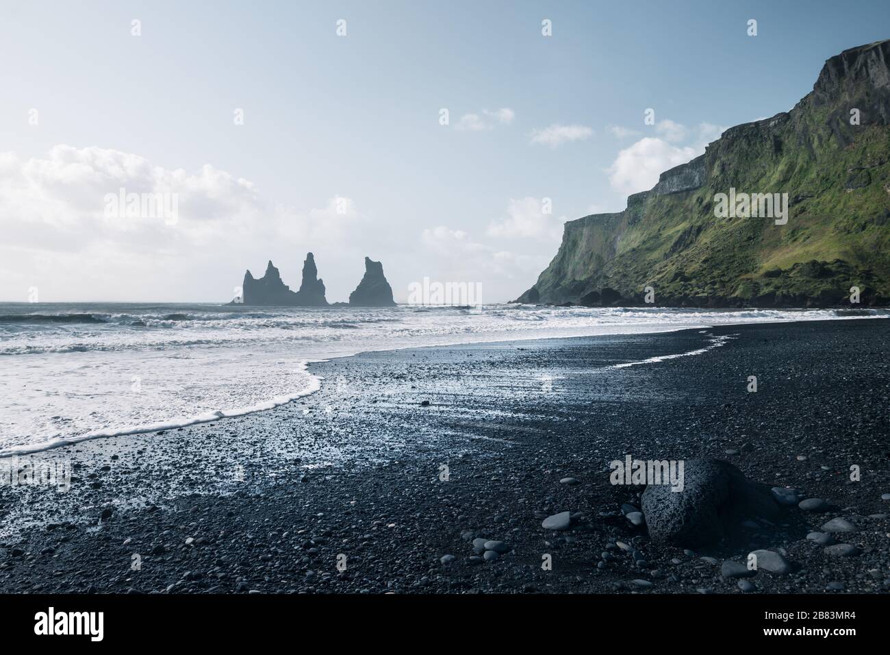 moody image disaturée de Vik plage avec formation de roche en arrière-plan et pièce de lave en premier plan sur clair soleil jour, Islande Banque D'Images
