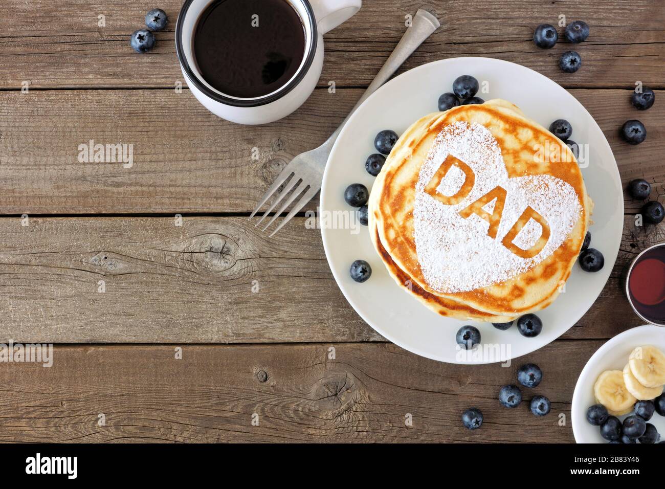 Crêpes en forme de coeur et lettres DAD. Concept de petit déjeuner de la fête des pères. Au-dessus de la vue bordure d'angle sur un arrière-plan rustique en bois. Banque D'Images