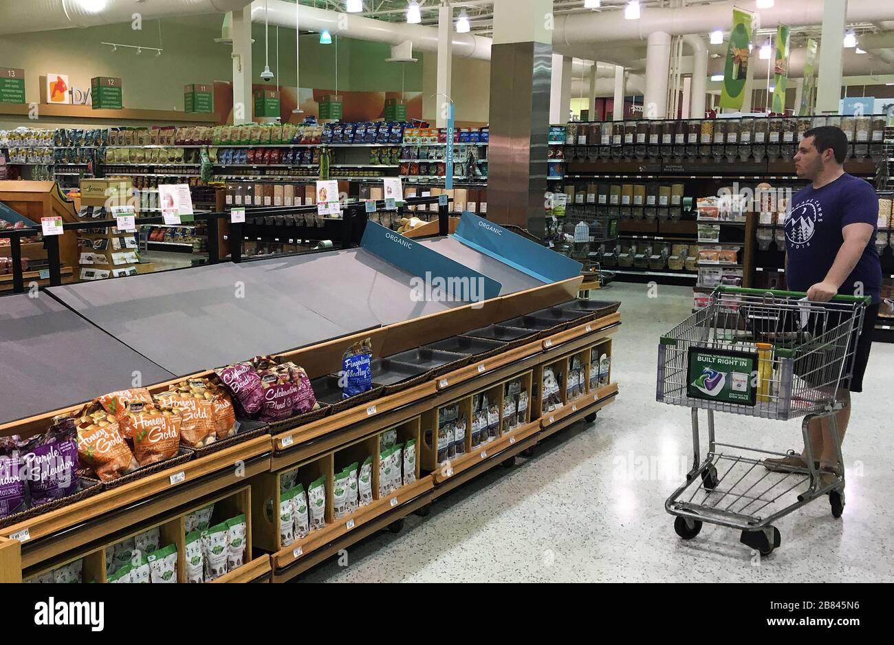 Orlando, États-Unis. 19 mars 2020. Un acheteur regarde un comptoir d'exposition de produits vides dans une épicerie Publix pendant les achats de panique.les gens font le stock de nourriture et de produits d'hygiène personnelle en réponse à la pandémie de coronavirus (COVID-19). Crédit: SOPA Images Limited/Alay Live News Banque D'Images