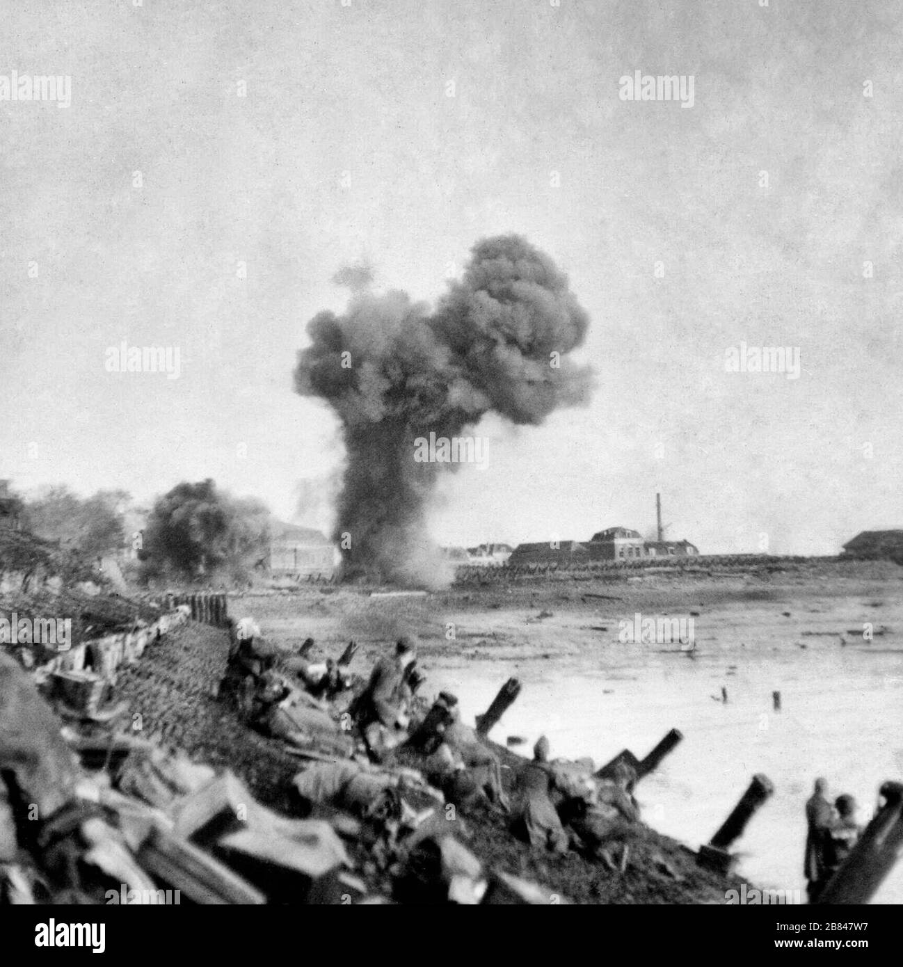 British Landings on Walcheren - les troupes britanniques d'assaut ont atterri sur Walcheren à l'aube le 1er novembre 1944 et la plupart de Flushing a été inclus dans la première tête de pont. Les débarquements ont été soutenus par un incendie de navires de guerre britanniques. L'objet de l'assaut est de faire taire les armes ennemies menaçant le passage de l'Escaut vers le port d'Anvers. Cette image montre que les troupes avancent le long du front de mer près de Flushing avec des obus qui débordent vers l'avant. Banque D'Images