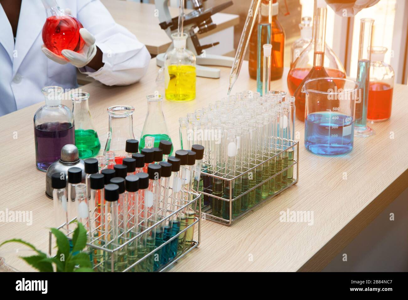 Échantillons de tests de laboratoire ou de laboratoire de recherche médicale ou solution avec pipette et plateau cellulaire à quatre-vingt-dix-six puits avec microscopes en arrière-plan. Banque D'Images