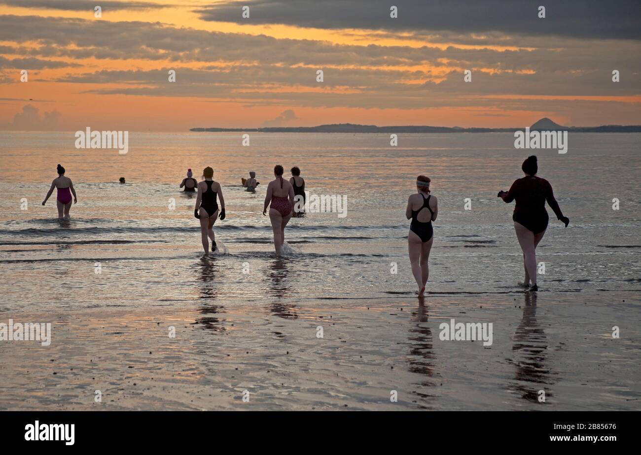 Portobello, Édimbourg, Écosse, Royaume-Uni. 20 mars 2020. Température 0 degrés centigrade comme la WanderWoman Ecosse célébrer printemps Equinox avec un lever de soleil natation. Pendant Equinoxes, l'inclinaison de la Terre (par rapport au Soleil) est de 0° et en raison de sa durée du jour et de la nuit est presque égale le jour Equinox, soit 12 heures. Banque D'Images