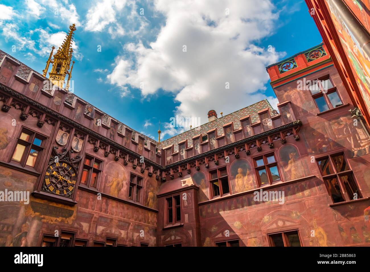 Vue panoramique sur la cour intérieure de l'hôtel de ville de Bâle. Elle est caractéristique de son toit coloré, de sa façade rouge, de ses fresques, de ses reliefs,... Banque D'Images