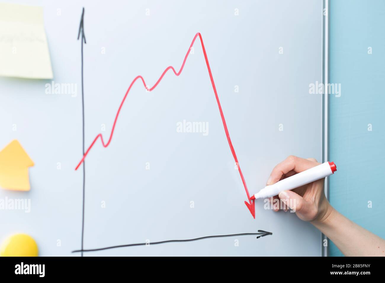 Flèche vers le bas à la main. Le concept d'une économie en chute libre, crise. Banque D'Images