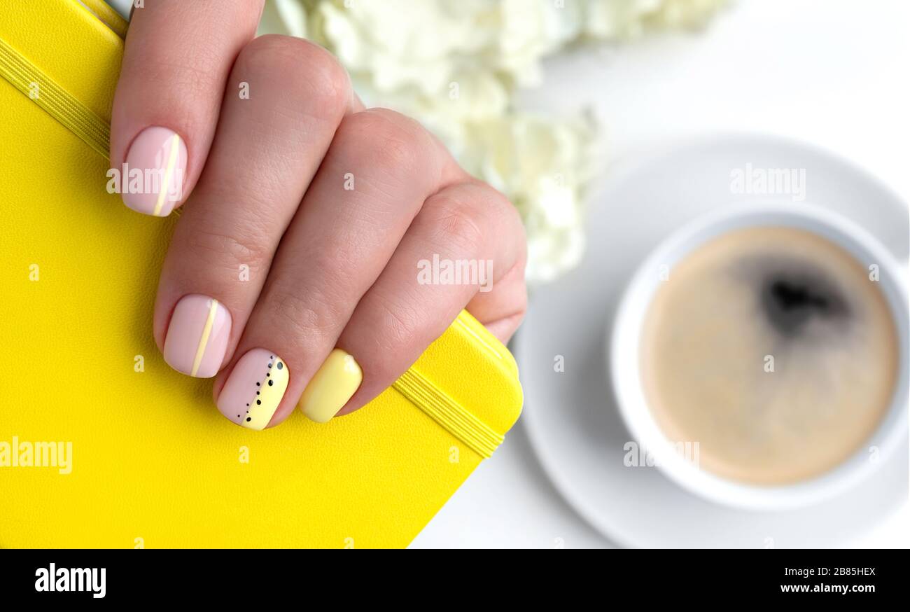 Les mains de la femme avec le motif clou de printemps d'été Banque D'Images