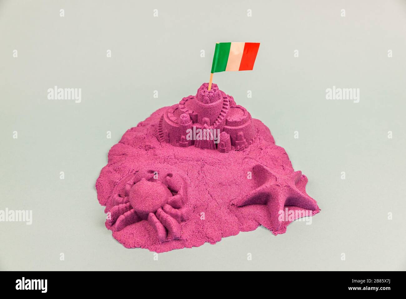 Une île avec drapeau italien sur un château de sable Banque D'Images